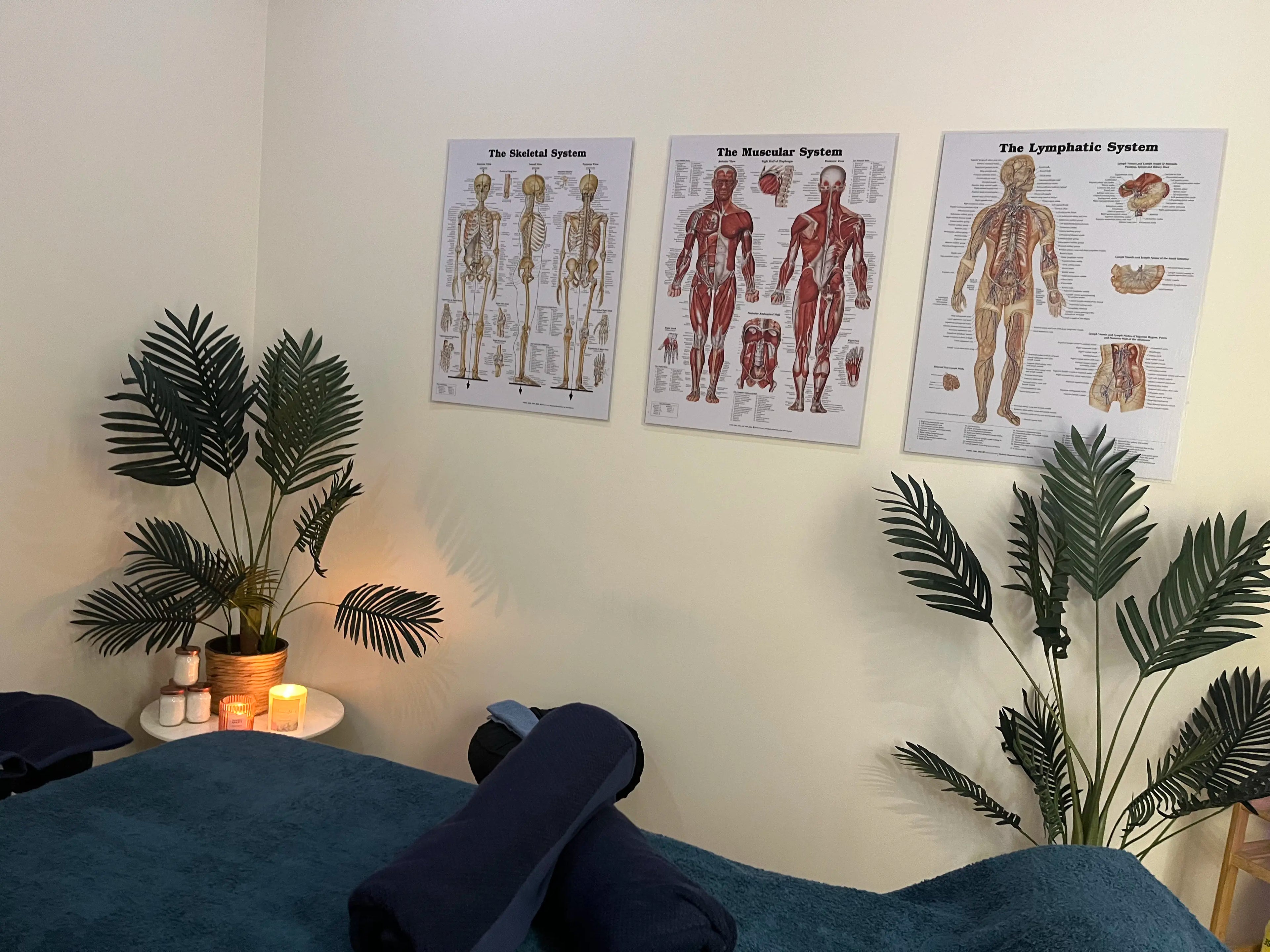 Massage table prepared for a client with ambient candlelight in the background, set for a relaxation massage.